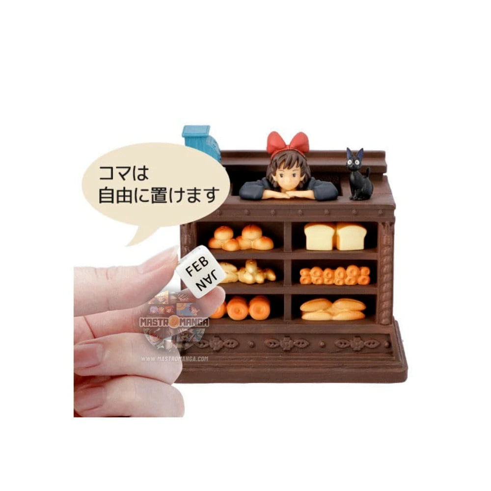 Calendario perpetuo ufficiale Studio Ghibli ispirato a Kiki - Consegne a domicilio, con Kiki in grembiule dietro il bancone del pane insieme al gatto Jiji e dadi per la data