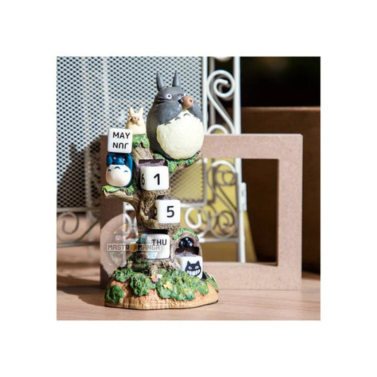 Calendario perpetuo ufficiale Studio Ghibli raffigurante il grande Totoro e i piccoli Totoro seduti su un tronco d'albero mentre suonano l'ocarina, con dadi numerati per la data