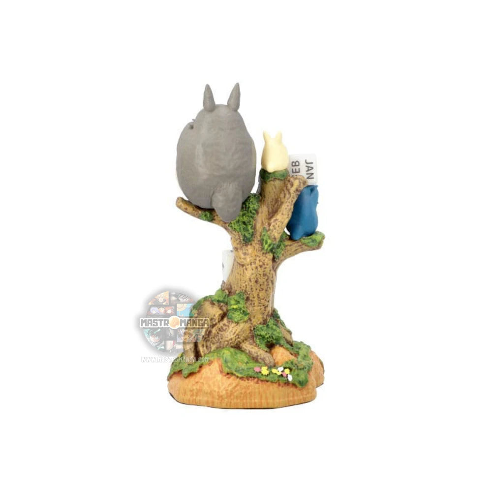 Calendario perpetuo ufficiale Studio Ghibli raffigurante il grande Totoro e i piccoli Totoro seduti su un tronco d'albero mentre suonano l'ocarina, con dadi numerati per la data