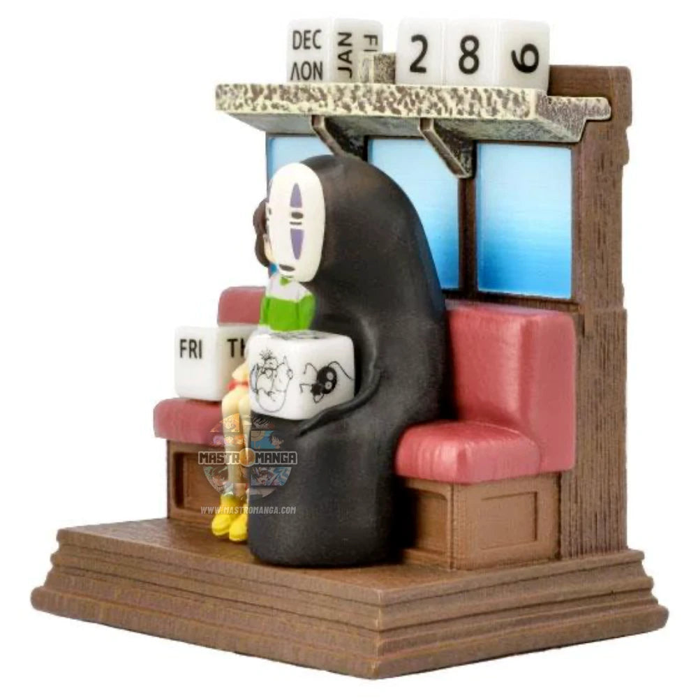 Calendario perpetuo ufficiale Studio Ghibli raffigurante Chihiro e Senzavolto seduti all'interno del treno Unabara di La Città Incantata, con dadi numerati per data e mese